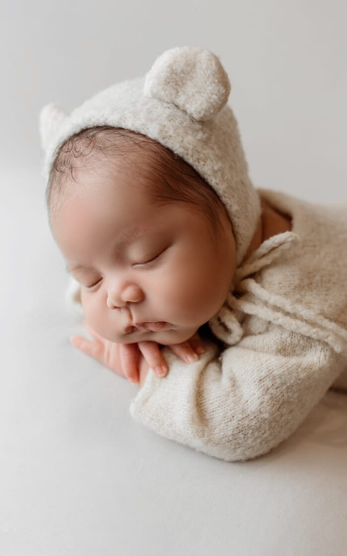baby seating on white textile
